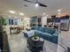 Comfortable living room featuring a teal sofa and a view into the kitchen and dining area at 1297 Paseo Del Oso Ln, Henderson, NV 89002