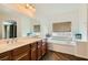 Bright bathroom boasts double sinks and a bathtub under a window at 1738 Sonoran Bluff Ave, Henderson, NV 89014