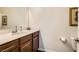 Well-lit half bath with dark wood vanity, granite countertop, and white toilet at 1738 Sonoran Bluff Ave, Henderson, NV 89014