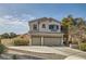 Charming two-story home features a three-car garage, paved driveway, and manicured landscaping for great curb appeal at 1738 Sonoran Bluff Ave, Henderson, NV 89014