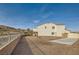 Tan two-story house with a gravel driveway and gated entrance at 1738 Sonoran Bluff Ave, Henderson, NV 89014