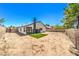 Home exterior showing a dirt backyard with block fencing and a patch of artificial grass at 3875 Sebasco Dr, Las Vegas, NV 89147