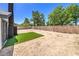 An expansive dirt backyard, defined by its block fence, complemented by a patch of artificial grass at 3875 Sebasco Dr, Las Vegas, NV 89147