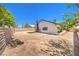 Exterior view of the home and its spacious dirt backyard, enclosed by a block fence at 3875 Sebasco Dr, Las Vegas, NV 89147