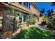 Landscaped backyard features well-maintained turf, mature palms, and a cozy outdoor lounge area at 4450 Palisades Canyon Cir, Las Vegas, NV 89129