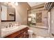 Inviting bathroom with a granite-look vanity, soaking tub, and a glass shower door at 4450 Palisades Canyon Cir, Las Vegas, NV 89129