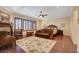A spacious bedroom features a sitting area, ceiling fan, shutters, and a large decorative rug at 4450 Palisades Canyon Cir, Las Vegas, NV 89129