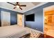 Bedroom with blue walls, hardwood floors, ceiling fan, and en-suite bath at 4450 Palisades Canyon Cir, Las Vegas, NV 89129