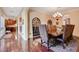 Formal dining room with hardwood floors, a large table, and views into the kitchen and hallway at 4450 Palisades Canyon Cir, Las Vegas, NV 89129