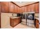 Convenient laundry room features granite countertops, cabinets and modern stainless steel washer and dryer at 4450 Palisades Canyon Cir, Las Vegas, NV 89129