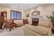 Comfortable living room with fireplace, plush chairs, and an elegant clock at 4450 Palisades Canyon Cir, Las Vegas, NV 89129