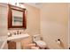 Elegant powder room with pedestal sink and dark wood trim at 4450 Palisades Canyon Cir, Las Vegas, NV 89129