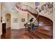 Elegant curved staircase with hardwood steps and ornate iron railing, next to a grand piano at 4450 Palisades Canyon Cir, Las Vegas, NV 89129
