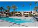 Community pool with palm trees and shaded seating areas at 4480 Sandy River Dr # 64, Las Vegas, NV 89103