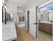 Modern bathroom with double vanity, mirrored closet, and light wood cabinets at 511 Dalgreen Pl, Henderson, NV 89012