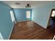 Light blue bedroom with wood-look floors and two windows at 529 Beckton Park Ave, Las Vegas, NV 89178