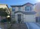 Two-story house with a beige exterior, two-car garage, and landscaping at 529 Beckton Park Ave, Las Vegas, NV 89178