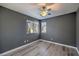 Bedroom with gray walls, ceiling fan and hardwood floors at 6217 Red Jamboree Ct, Las Vegas, NV 89130