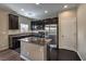 Modern kitchen with dark wood cabinets, granite countertops, and stainless steel appliances at 6217 Red Jamboree Ct, Las Vegas, NV 89130