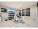 Modern dining area with a glass table, white chairs, and bright natural light at 6834 Compass St, North Las Vegas, NV 89084