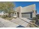 Modern home exterior with gray garage door and landscaped front yard at 6834 Compass St, North Las Vegas, NV 89084