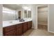 Bathroom with double vanity, large mirror, and walk-in closet at 8467 Bismark Sapphire St, Las Vegas, NV 89139