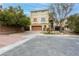 Two-story house with a tan exterior, attached garage, and landscaping at 8467 Bismark Sapphire St, Las Vegas, NV 89139