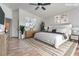 Virtually staged main bedroom with wood floors, large bed, and ceiling fan at 8627 Roping Rodeo Ave # 103, Las Vegas, NV 89178