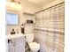 Simple bathroom with gray vanity and striped shower curtain at 8836 Big Bear Pines Ave, Las Vegas, NV 89143