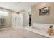 Modern bathroom with glass shower, soaking tub, and walk-in closet access at 10286 Jade Gardens Dr, Las Vegas, NV 89135