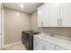 Bright laundry room features white cabinets, a utility sink, and modern washer and dryer at 10286 Jade Gardens Dr, Las Vegas, NV 89135