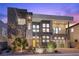 Modern two-story home with yellow door and city views at dusk at 10955 Mojave Spring Dr, Las Vegas, NV 89135