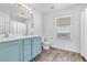 Bright bathroom with double vanity, white fixtures, and wood laminate flooring at 1129 Majestic Canyon St, Henderson, NV 89052