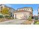 Two-story house with beige exterior, two-car garage, and landscaping at 1129 Majestic Canyon St, Henderson, NV 89052