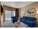 Spacious living room featuring a blue sofa and access to a private balcony at 211 E Flamingo Rd # 615, Las Vegas, NV 89169