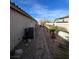 A stone backyard pathway runs along the exterior wall with HVAC units, and small palm trees line the walkway at 2540 E Sparrow Way, Pahrump, NV 89048
