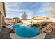 Beautiful backyard swimming pool with a rock waterfall feature, surrounded by lush landscaping at 2540 E Sparrow Way, Pahrump, NV 89048