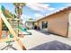 Large backyard with covered patio, playset, and artificial turf at 3905 Blairmoor St, North Las Vegas, NV 89032