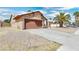 Tan house with brown garage door and gravel landscaping at 3905 Blairmoor St, North Las Vegas, NV 89032