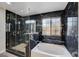 Modern bathroom with a frameless glass shower and dark marble tile at 5236 Woodlawn Ln, Las Vegas, NV 89130