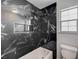 Luxury bathroom with black marble tile, a soaking tub and rainfall shower head at 5236 Woodlawn Ln, Las Vegas, NV 89130