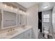 Modern bathroom with double sinks, white cabinets, and a marble-tiled shower at 5236 Woodlawn Ln, Las Vegas, NV 89130