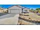 Well-maintained front yard with desert landscaping, featuring a two-car garage and neutral color palette at 5236 Woodlawn Ln, Las Vegas, NV 89130