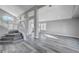 Bright living room featuring a staircase, gray walls and floors, with plenty of natural light at 5236 Woodlawn Ln, Las Vegas, NV 89130