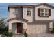 Two-story house with brown door, attached garage, and Spanish-style roof at 5748 Remy Rain St, Las Vegas, NV 89148