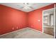 The spacious bedroom features red walls, carpet and a ceiling fan at 5804 Sassa St, Las Vegas, NV 89130