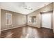 Bright empty bedroom features wood-look floors, ceiling fan, and two sunny windows at 5804 Sassa St, Las Vegas, NV 89130