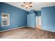 Spacious bedroom with blue walls, wood-look tile floors, and a doorway leading to the ensuite bathroom at 5804 Sassa St, Las Vegas, NV 89130