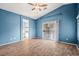 Blue bedroom with wood-look tile floors, sliding glass doors, and ensuite bathroom at 5804 Sassa St, Las Vegas, NV 89130