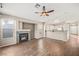 Open-concept living room with wood-look tile flooring, fireplace, and breakfast bar to the adjacent white kitchen at 5804 Sassa St, Las Vegas, NV 89130